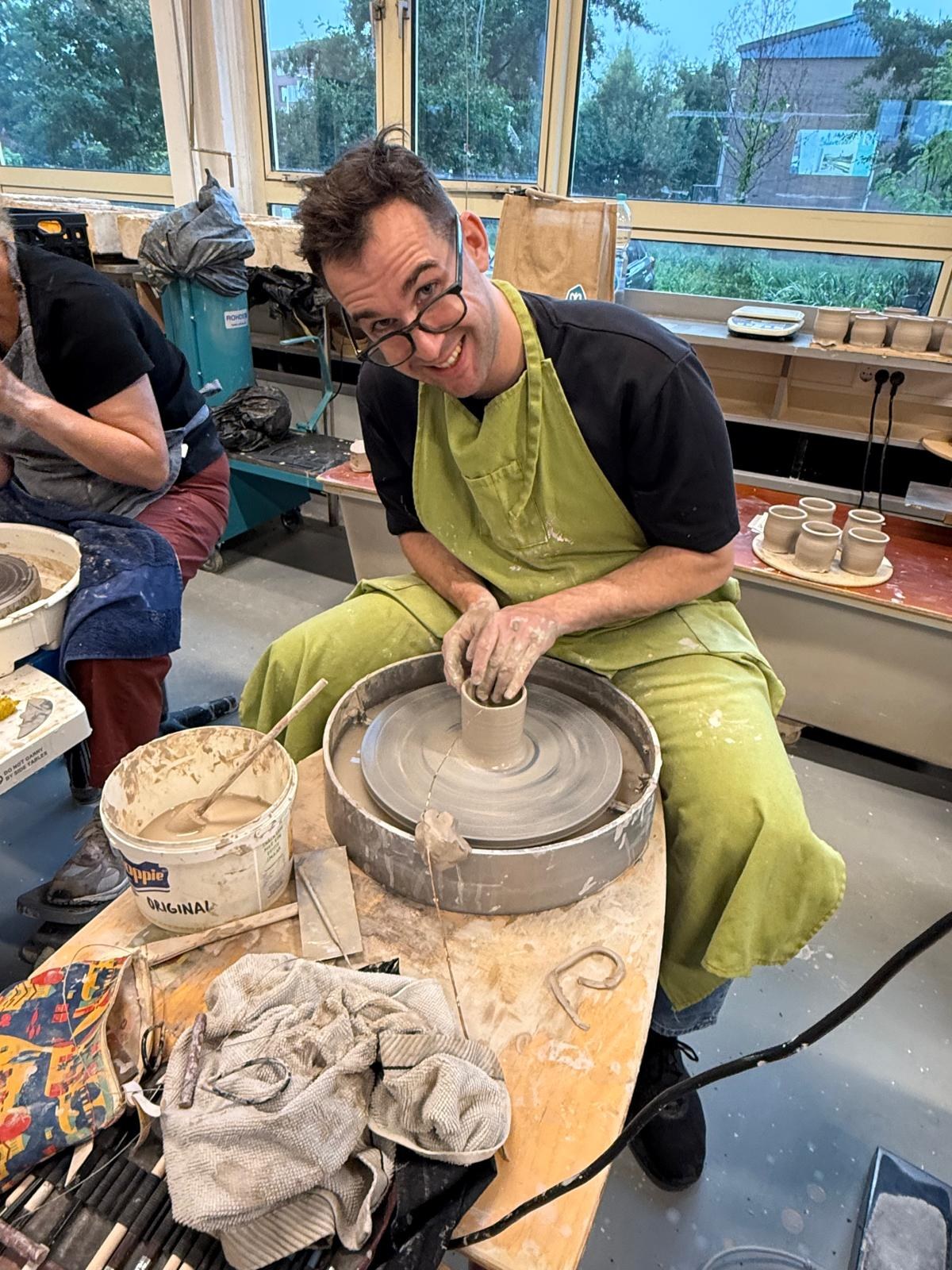 Michael throwing a pot at the wheel
